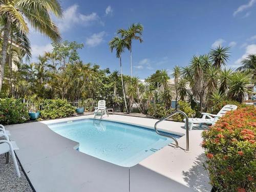 a large swimming pool with chairs and palm trees at Blue Paradise - 7 DAY MINIMUM STAY in Marathon