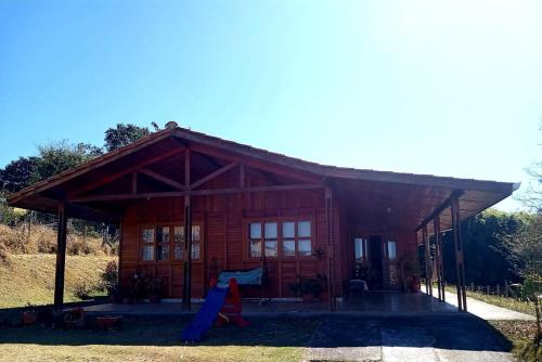 a log cabin with a slide in front of it at Casa de Campo in Caldas