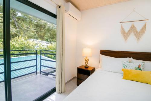 a bedroom with a bed and a balcony at Casa Ola Ini Studio Playa Grande in Playa Grande