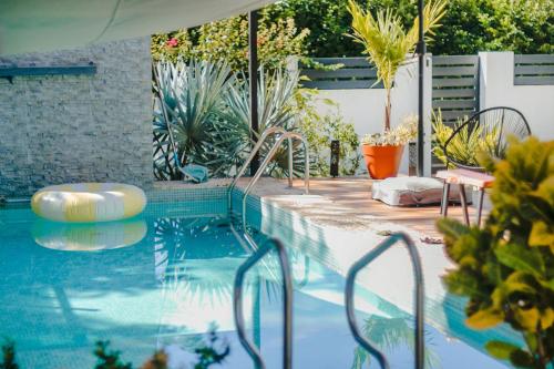 a swimming pool with chairs and plants in a yard at Casa Ola Ini Studio Playa Grande in Playa Grande