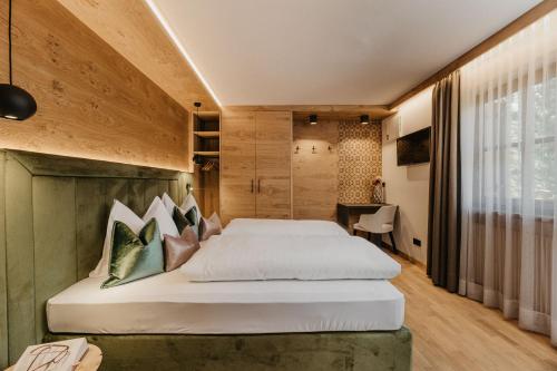 a bedroom with a large bed and a desk at Miraval Perathoner Andreas in Ortisei