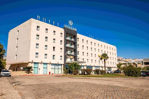 a white building with a sign on top of it at VIP Executive Santa Iria Hotel in Santa Iria da Azóia