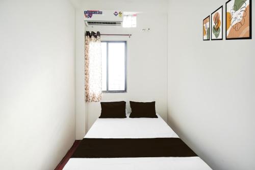 a small white bedroom with a bed in it at SPOT ON Ap Logde in Māharjhari