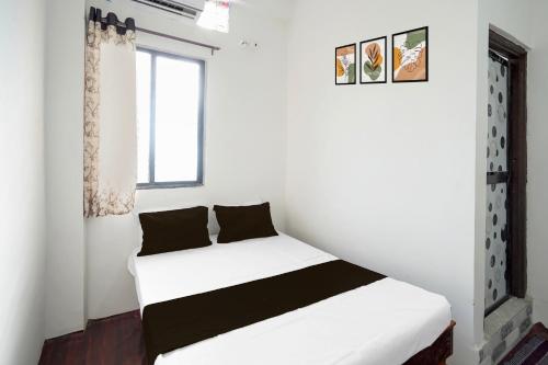 a white bed in a room with a window at SPOT ON Ap Logde in Māharjhari