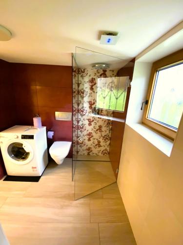 a bathroom with a washing machine and a toilet at "Nestl" in Bad Häring