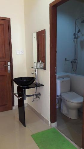 uma casa de banho com um lavatório e um WC em Three Ayu Family House em Ubud