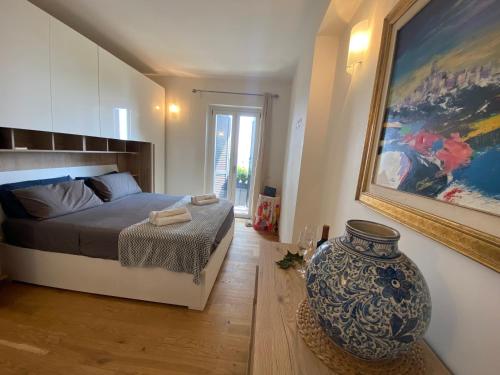 a bedroom with a bed and a vase in a room at Trevignano Casa fronte lago in Trevignano Romano