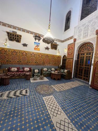 Una sala de estar con una habitación grande con suelo de baldosas azules en Riad Dar Bahja - More Than a Stay, en Fez