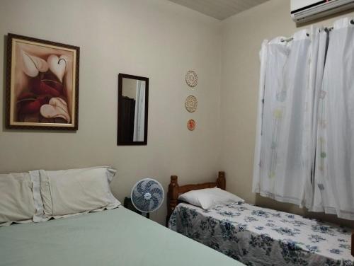 Un dormitorio con dos camas y un espejo. en Paraíso dos Coqueiros, en Fortim