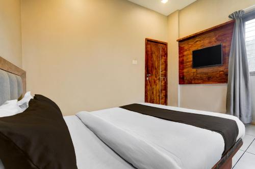 a bedroom with a bed and a tv on the wall at Hotel O Maharashtra Darbar Gonde in Pādli