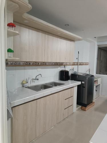 a kitchen with a sink and a stove at Apto San José in Armenia