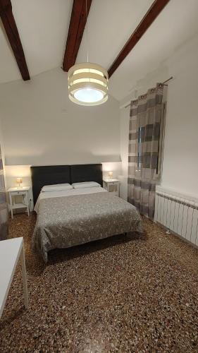 a bedroom with a large bed and a chandelier at Corte Loredana Only adult - No Housekeeping in Venice