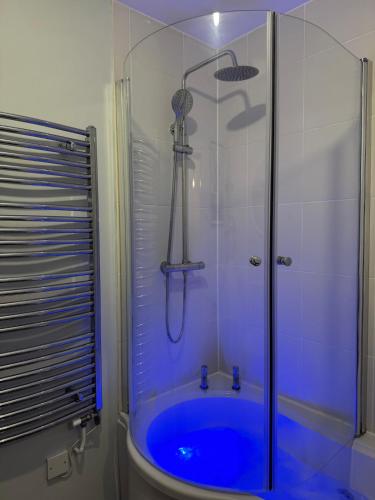 a shower with a blue tub in a bathroom at Willow Cottage in North Muskham