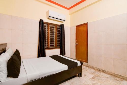 ein Schlafzimmer mit einem Bett und einem Fenster in einem Zimmer in der Unterkunft Hotel O D Stay Inn in Rushikonda