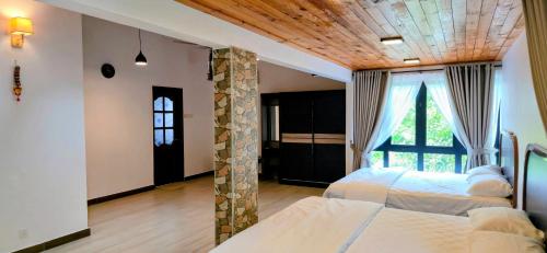 a bedroom with two beds and a large window at Gasing WheelHouse in Petaling Jaya