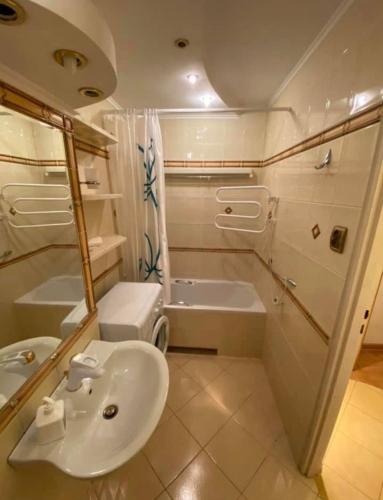 a bathroom with a sink and a tub and a toilet at Lodgia Apartments in Skorka
