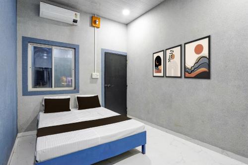 a bedroom with two beds and paintings on the wall at Hotel O The Lotas Gardan in Sipra