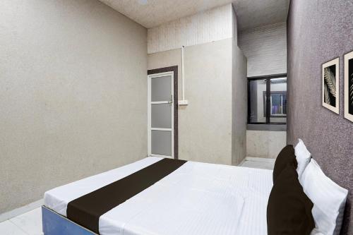 a bedroom with a large white bed in a room at Hotel O The Lotas Gardan in Sipra