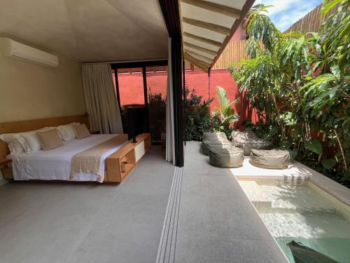 a bedroom with a bed and a swimming pool at Pousada Okas de Camburizinho in São Sebastião