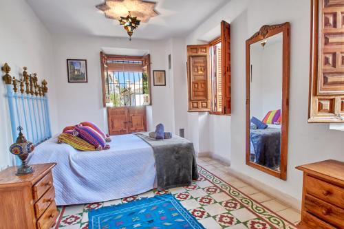 a bedroom with a bed and a mirror at Oripando Private Rooms in Granada