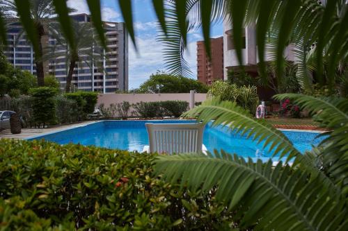una sedia bianca seduta accanto a una piscina di La Reserve a Porlamar