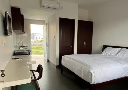 Un dormitorio con una cama y una cocina con fregadero. en Naungan Intaran Mandala, en Sanur