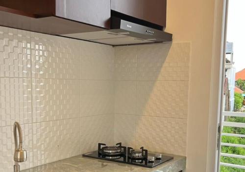 Una cocina con un horno de estufa en una cocina en Naungan Intaran Mandala, en Sanur