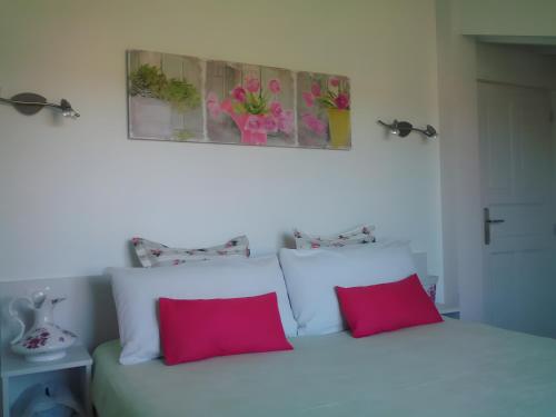 een slaapkamer met een wit bed en 2 rode kussens bij Charmant appartement à Ainhoa in Aïnhoa