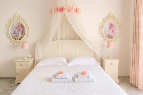 a bedroom with a white bed with two boxes on it at Fairy home Porto Heli in Porto Heli