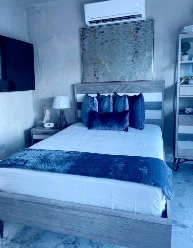 a bedroom with a large bed with blue pillows at Entire home for 2 with private pool and plenty of amenities in Rio Grande, Puerto Rico in Rio Grande