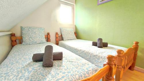 deux lits jumeaux dans une chambre aux murs verts dans l'établissement La Maison de Marylou, calme et nature - 6 pers, à Gouarec