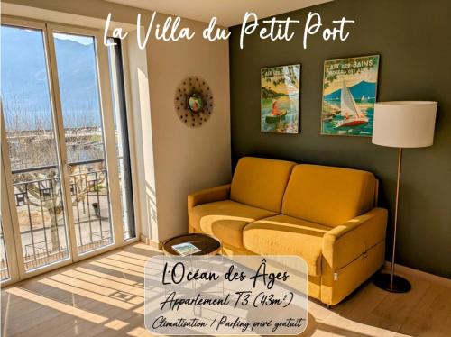 a living room with a couch and a window at LA VILLA DU PETIT PORT - Appartements & chambres in Aix-les-Bains