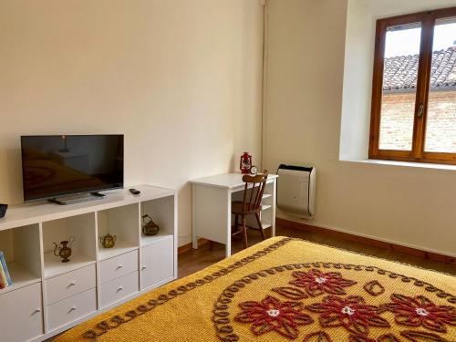 a living room with a television and a table at Teatro Inn - Timeless Charm in Correggio