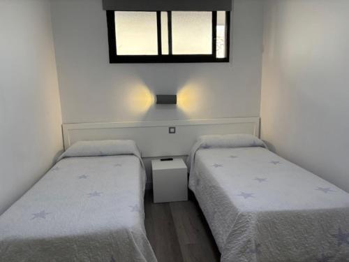 two beds in a small room with a window at Riviera Paradise in Las Palmas de Gran Canaria