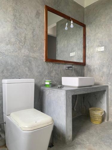 a bathroom with a white toilet and a sink at Villa Unawatuna in Unawatuna