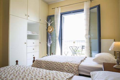a bedroom with two beds and a window at Villa Xenia in Karavadhos