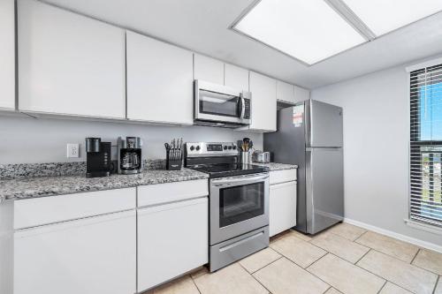 a kitchen with white cabinets and a stove top oven at Wind Drift 408SW in Perdido Key