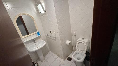 a bathroom with a sink and a toilet and a mirror at شاليه مارفن درة العروس البرادايس in Durat  Alarous