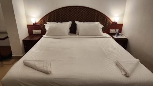 a bedroom with a large bed with white sheets and pillows at Casa Linda in Cochin