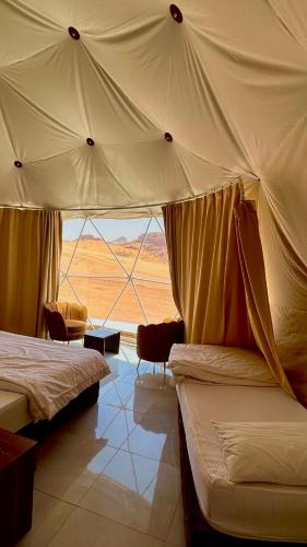 um quarto com duas camas e vista para o deserto em Desert Pearl Luxury Camp em Wadi Rum