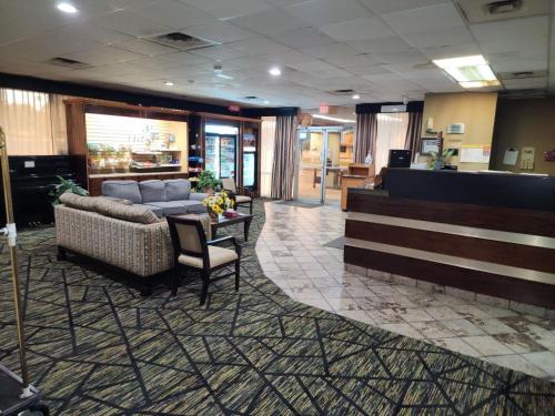 eine Lobby mit einem Sofa und einem Tisch und Stühlen in der Unterkunft Discovery Inn Lafayette in Lafayette