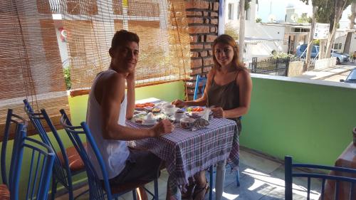 un hombre y una mujer sentados en una mesa en Mavi Pansiyon, en Bodrum City