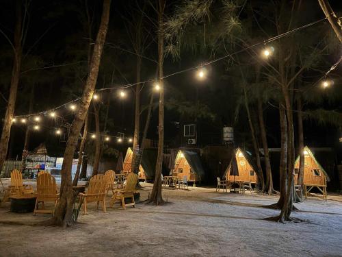 a group of lodges with chairs and trees at night at Teepee Hut Fan room in San Felipe