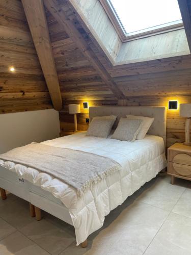 a bedroom with a large bed with wooden ceilings at Duplex Haut de Gamme neuf - 10 personnes - App 004 in Saint-Sorlin-dʼArves