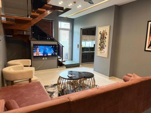 a living room with a couch and a television at Cozy 3BR Entire Home In DHA Rahbar Lahore in Lahore