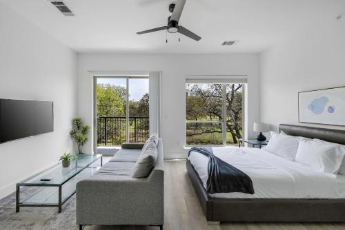 a bedroom with a bed and a couch and a tv at Landing Apartments - Denton in Denton