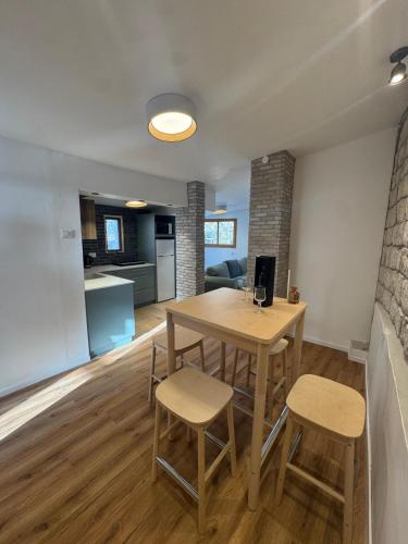 a kitchen and living room with a wooden table and chairs at לוריא יוקרה בעתיקה in Safed
