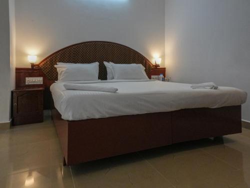 a large bed with white sheets and pillows at Casa Linda in Cochin