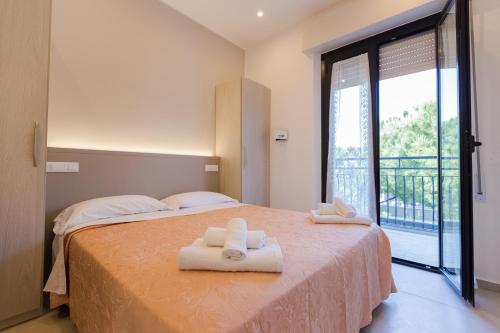 a bedroom with a bed with two towels on it at Hotel Altamarea in Misano Adriatico