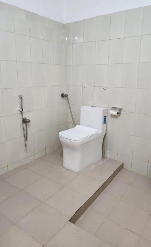 a bathroom with a white toilet in a stall at Casa Linda in Cochin